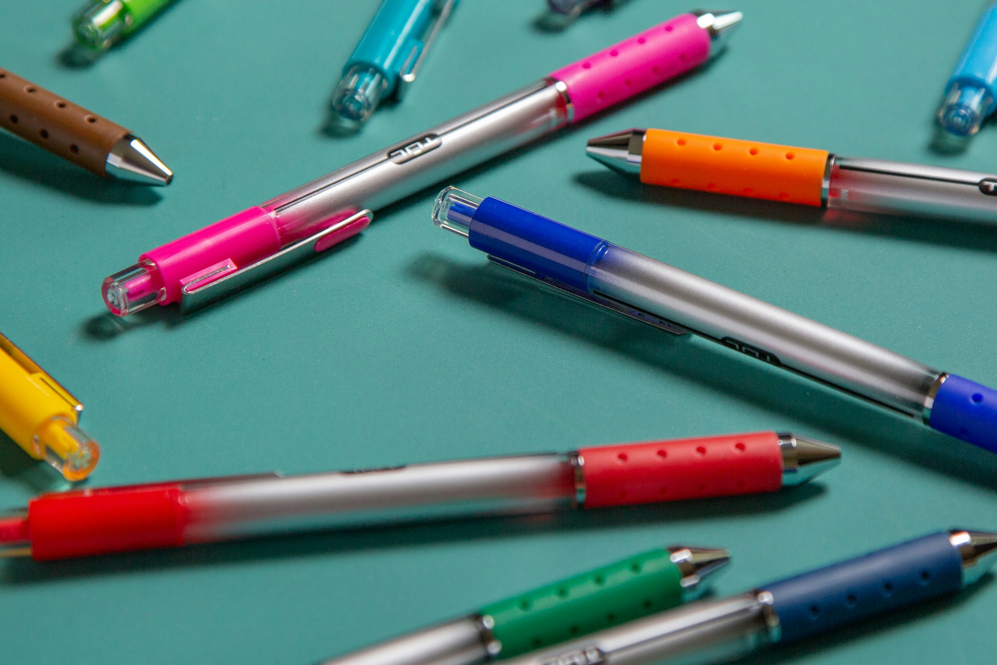 Bolígrafos de colores rosa, azul y verde organizados en conjunto