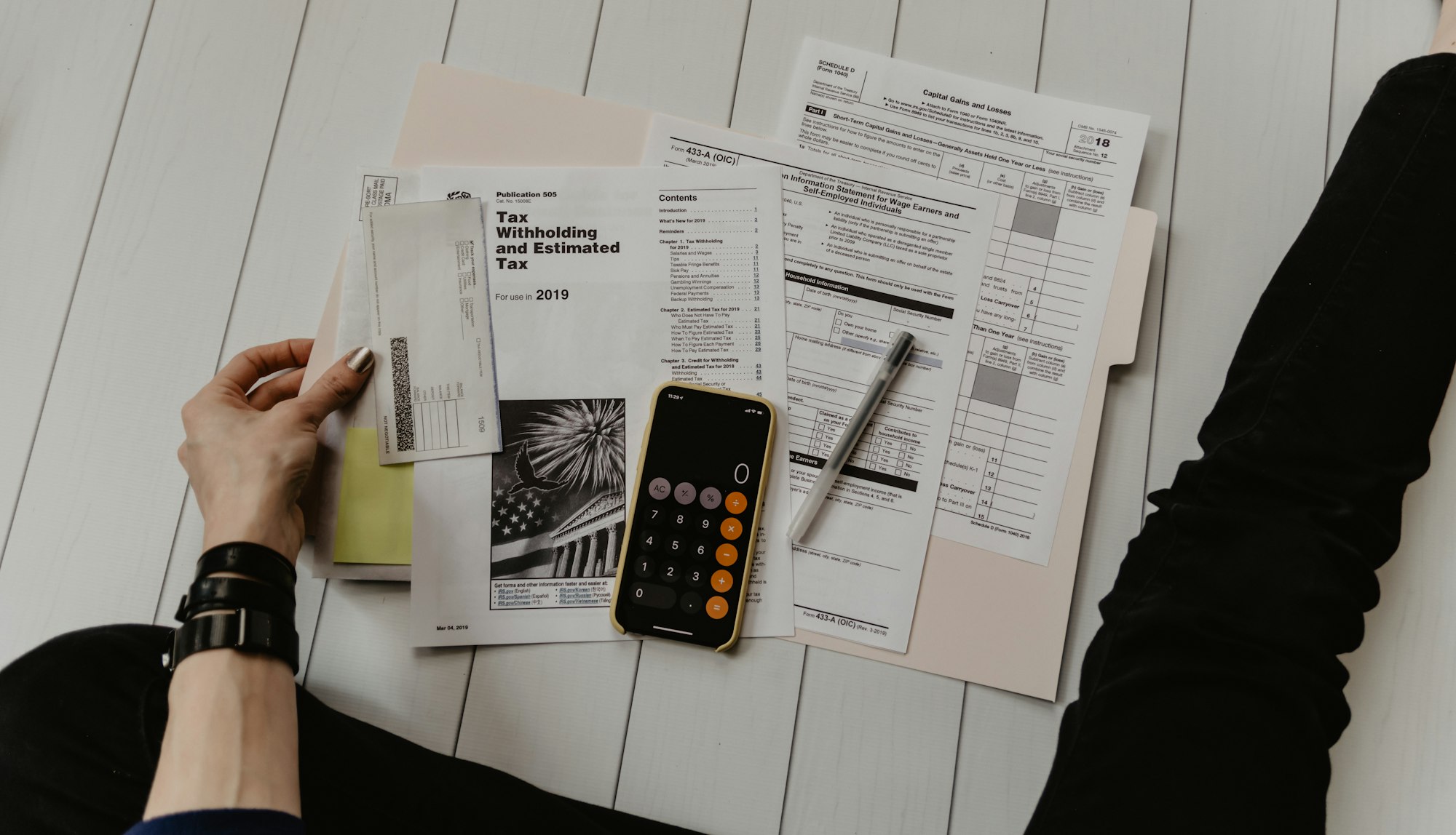 Documentos, carpetas y calculadora sobre un escritorio de oficina